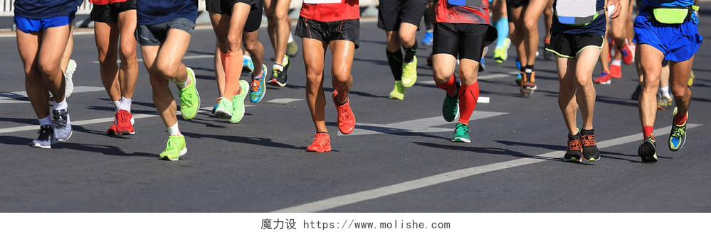 拍摄马拉松运动员们的腿部特写在城市道路上运行的马拉松跑步者腿